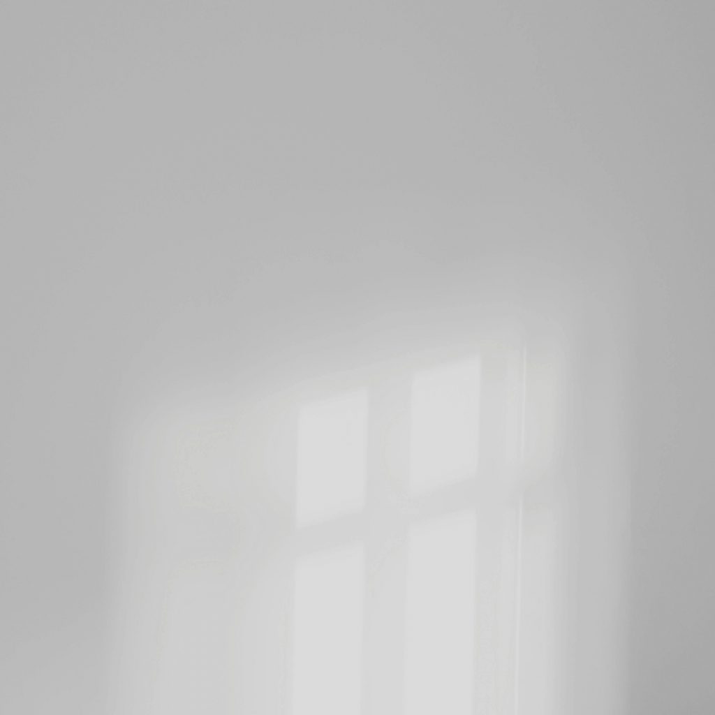 Soft light reflection on a plain white wall creating a minimalist aesthetic.